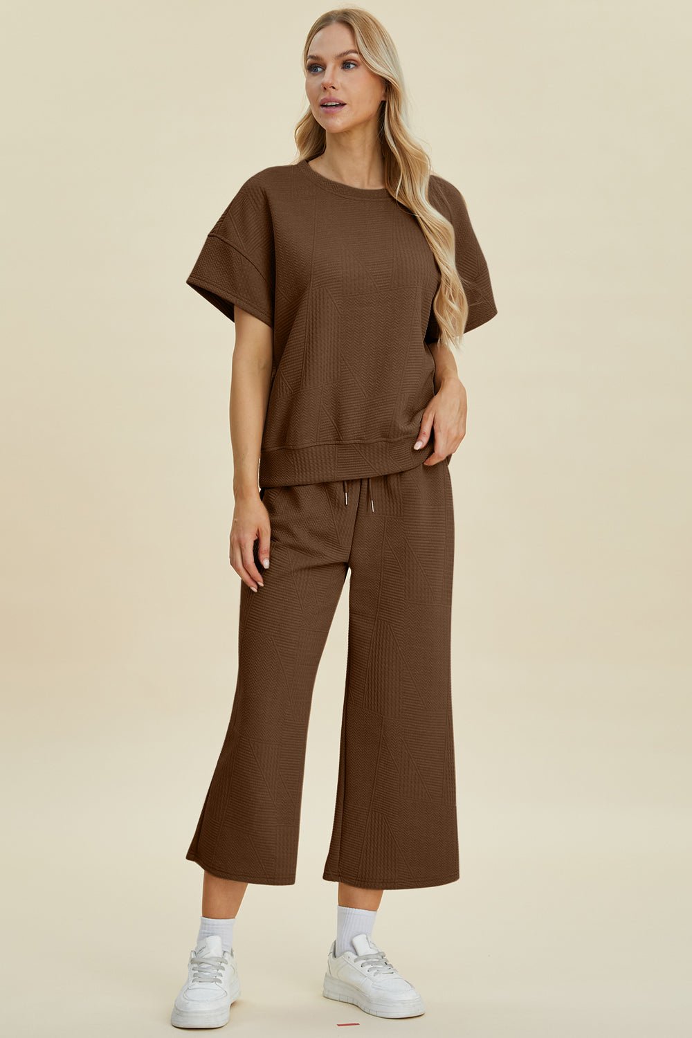 Woman in brown textured round neck top and pants set with drawstring, slightly stretchy two-piece outfit.
