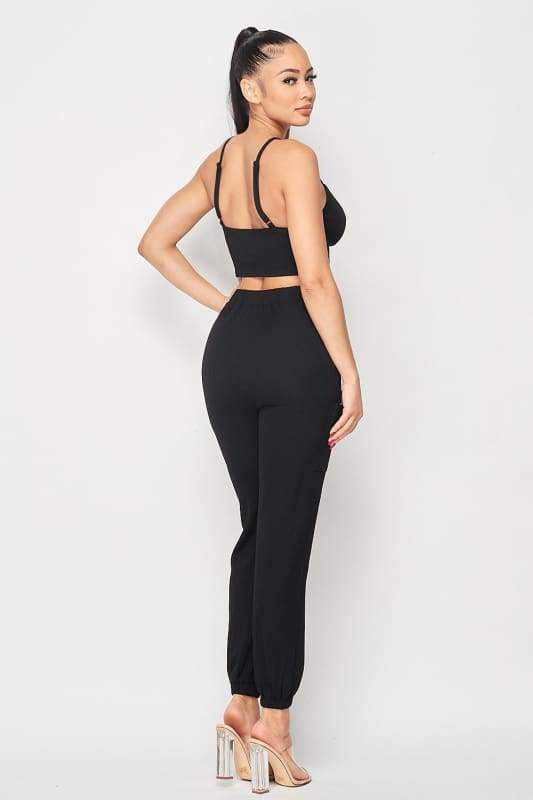 Woman wearing black ribbed cropped cami and joggers set, standing sideways with high ponytail, showcasing Won't Forget Me Two-Piece Set.