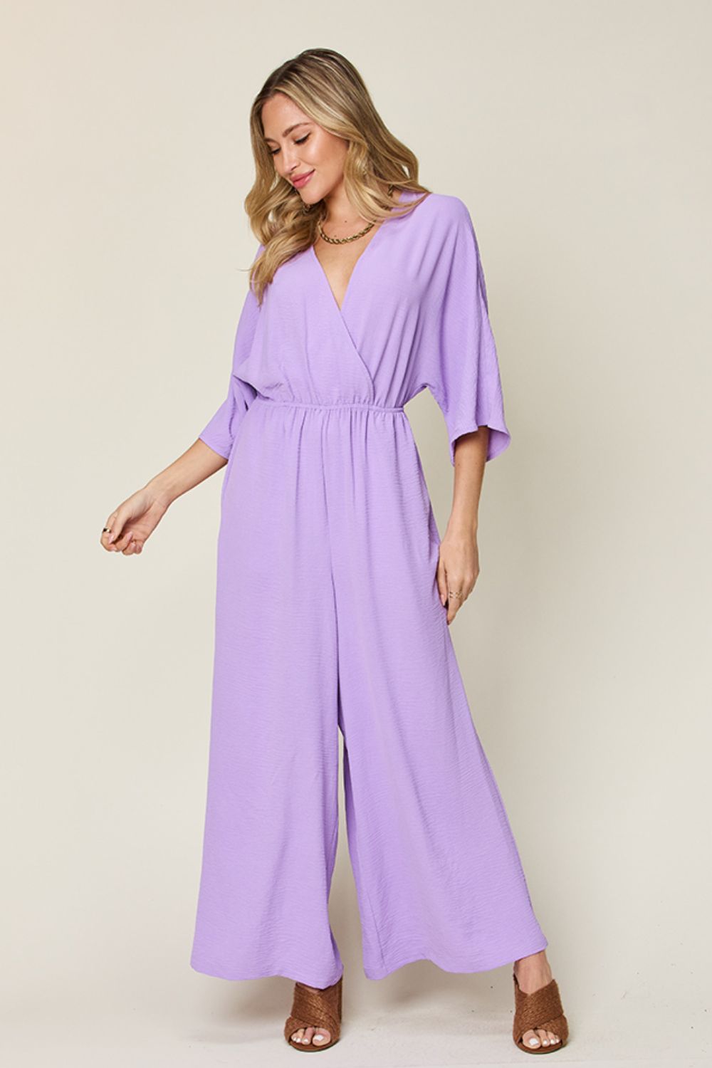 Lavender surplice wide leg jumpsuit with pockets, featuring a tied ruched design, made of 95% polyester and 5% spandex.