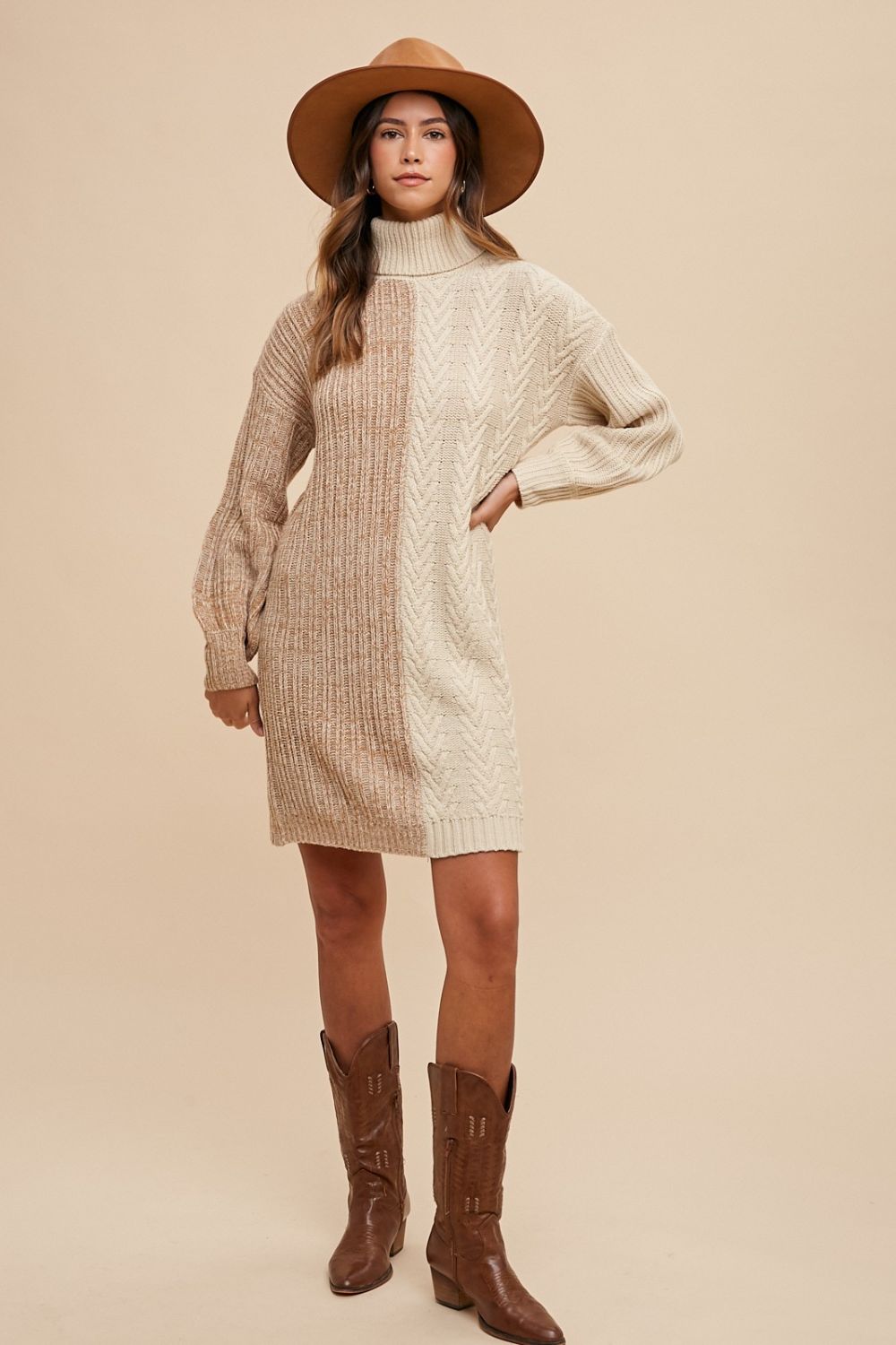 Woman wearing a winter color block turtleneck sweater dress with a hat and boots, showcasing cozy style and ribbed texture.