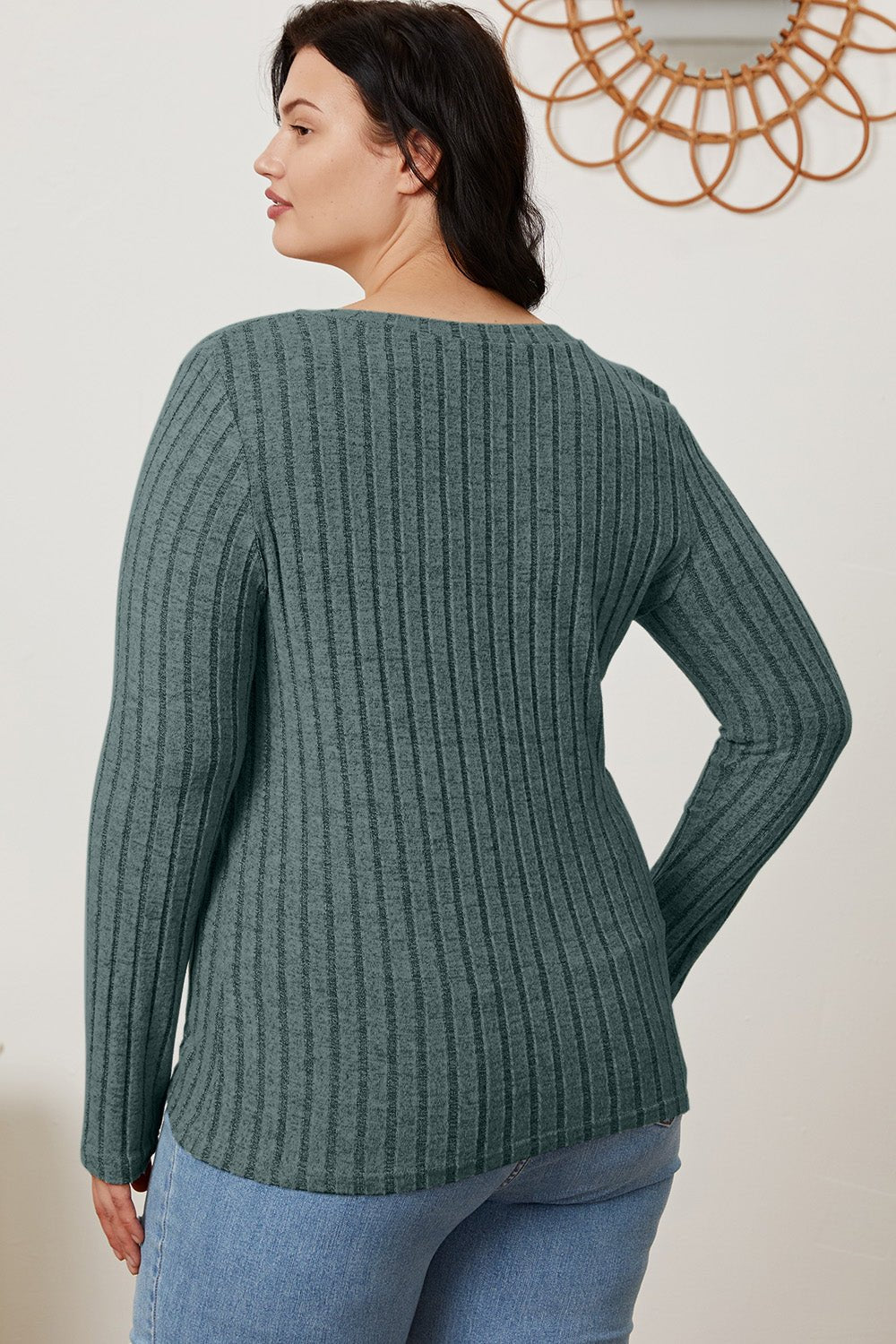 Woman wearing Basic Bae Full Size Ribbed V-Neck Long Sleeve T-Shirt in green, showcasing back design with slight stretch fabric.