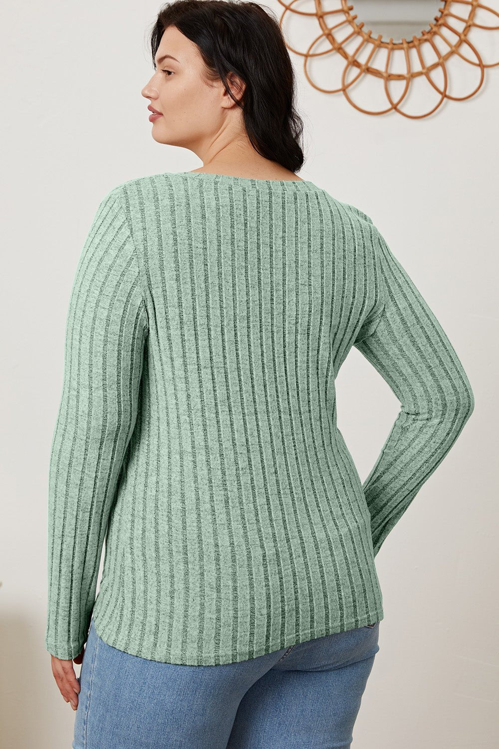 Woman wearing green Basic Bae ribbed V-neck long sleeve T-shirt, shown from the back, paired with casual blue jeans.