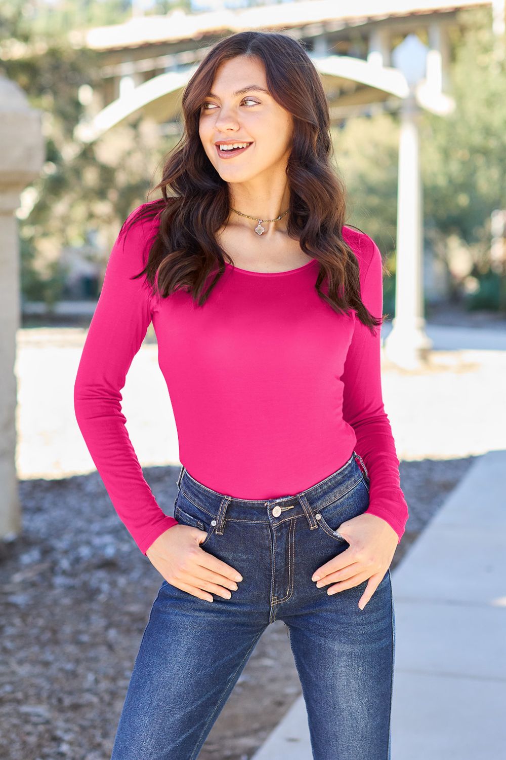 Woman in pink Basic Bae long sleeve bodysuit and jeans outdoors