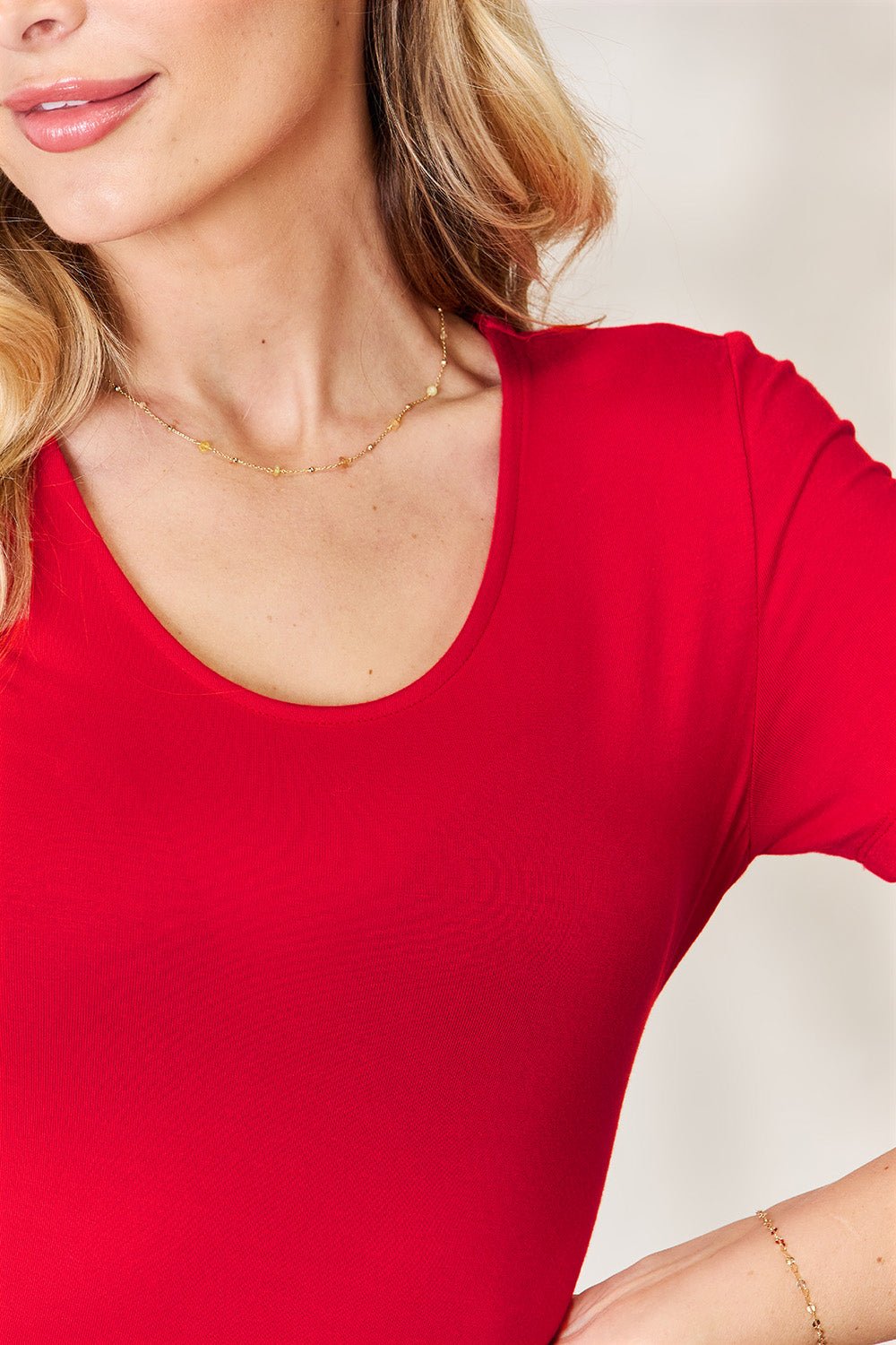 Red Basic Bae round neck short sleeve bodysuit close-up, showing fabric texture and neckline detail.
